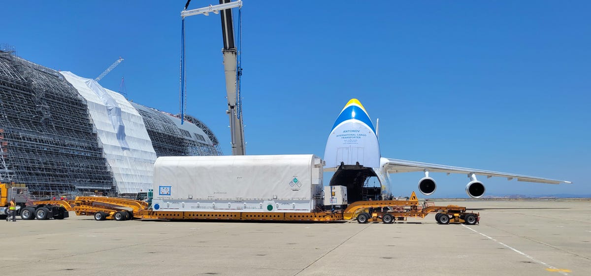 Hughes' Jupiter 3 satellite, packaged in a large white container, is loaded onto a bulging Antonov cargo jet in Silicon Valley for shipment to Florida for its launch.