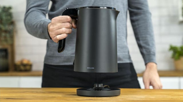 person holding black electric kettle 
