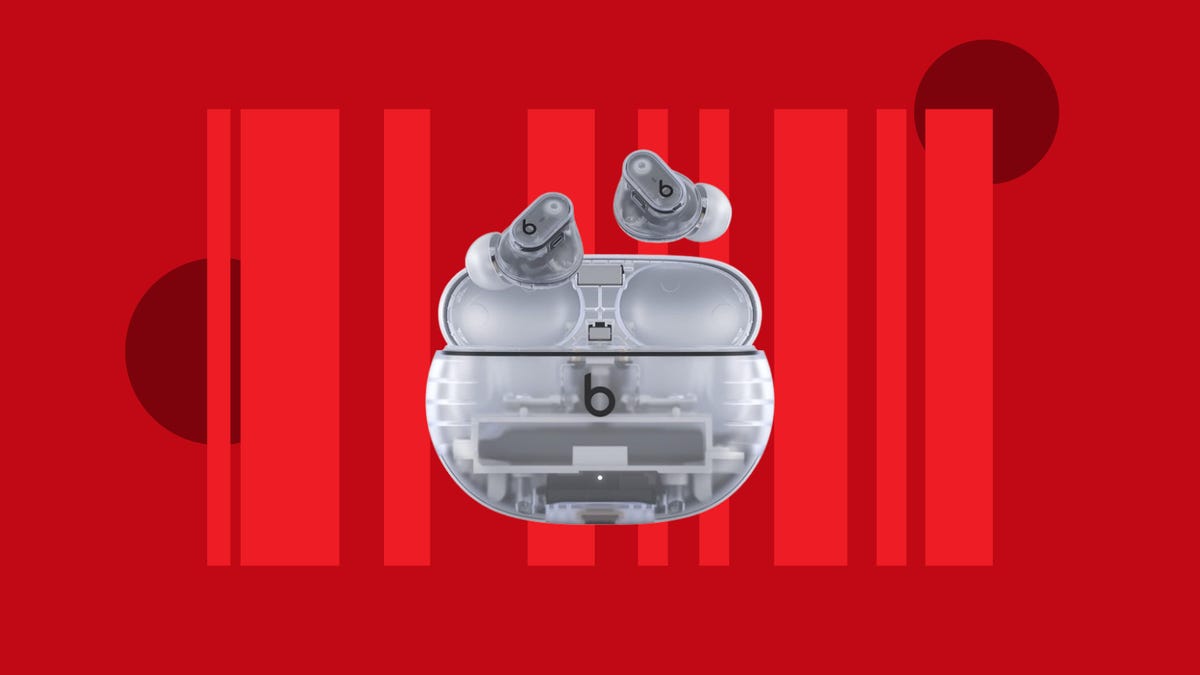 A pair of transparent Beats Studio Buds Plus earbuds are displayed against a red background.