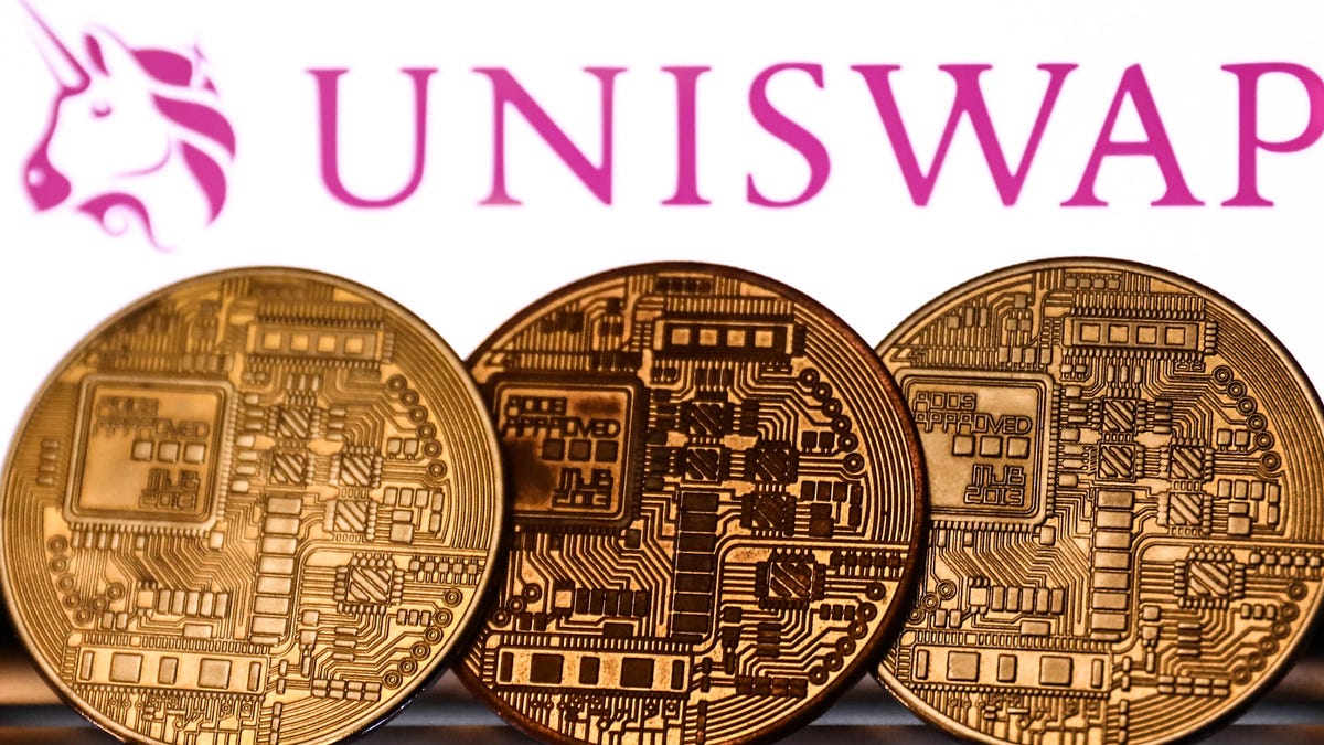 Three cryptocurrency coins in front of Uniswap's logo.