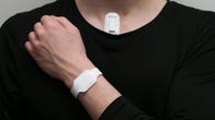 A person in a black shirt shows where the wristband and device itself would be attached.