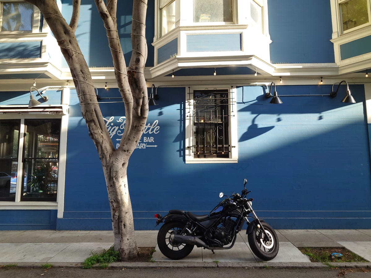 A picture of a motorcycle in front of a blue building