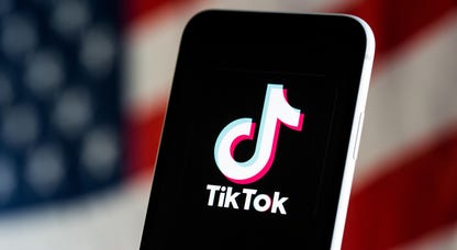 TikTok logo on a phone with the American flag in the background