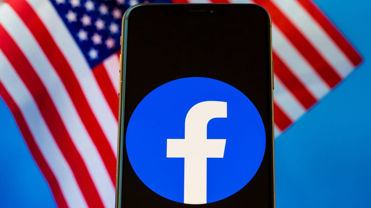 Facebook logo on a phone screen, with US flags in the background