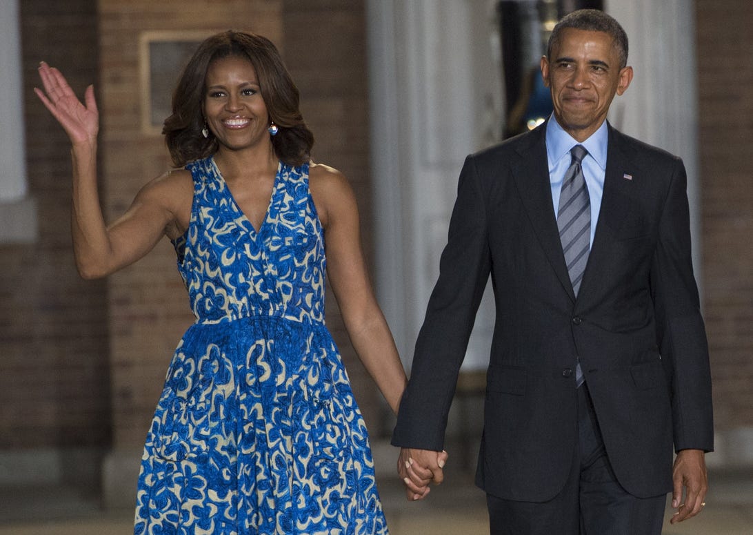 Barrack and Michelle holding hands as Michelle waves.