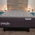 The Purple Rejuvenate Plus mattress in between two blue and white night stands. 