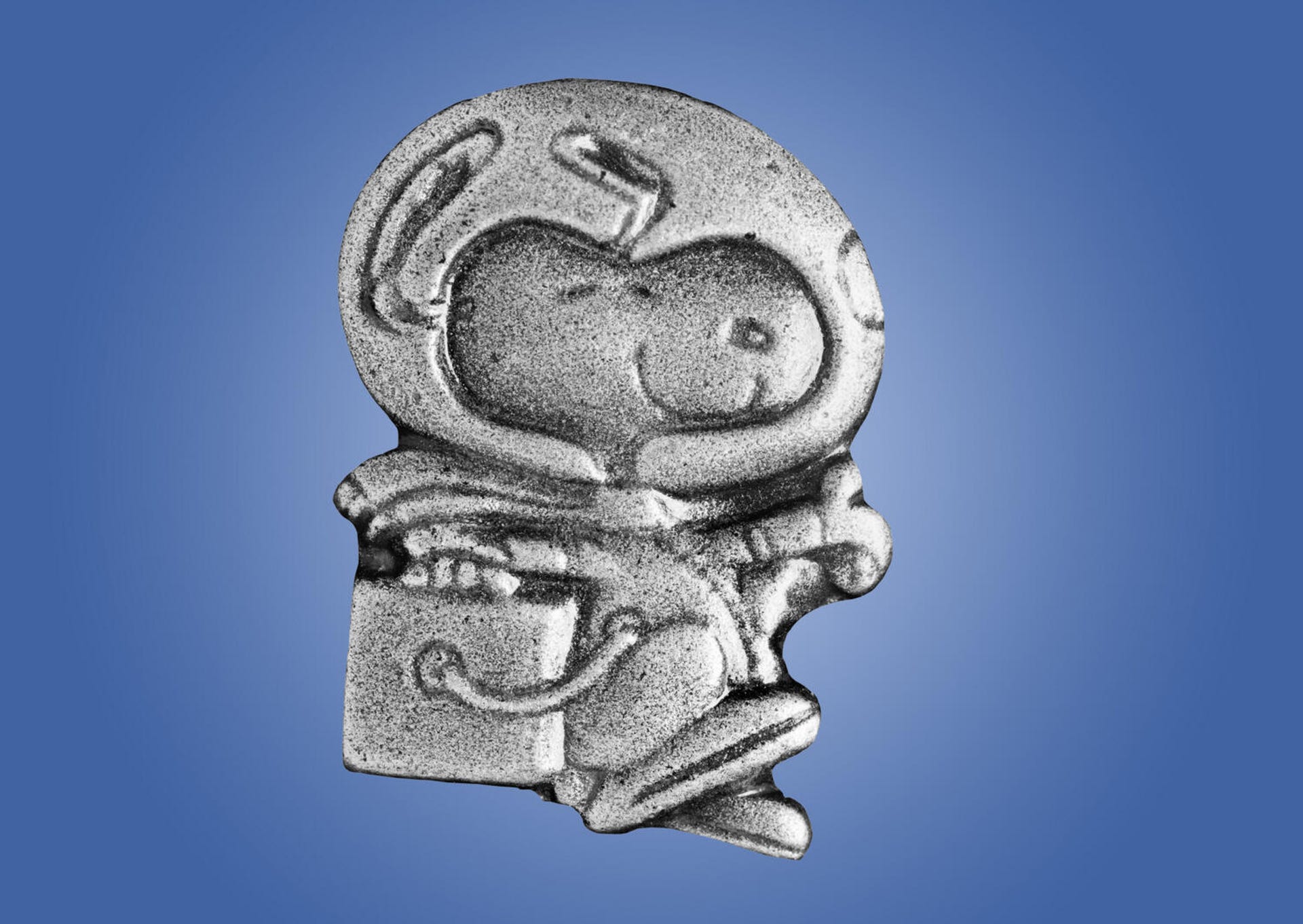 A silver pine representing Peanuts dog Snoopy wearing an astronaut outfit.