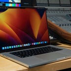 The Apple MacBook Pro 16 open in front of a studio's multicamera video control setup