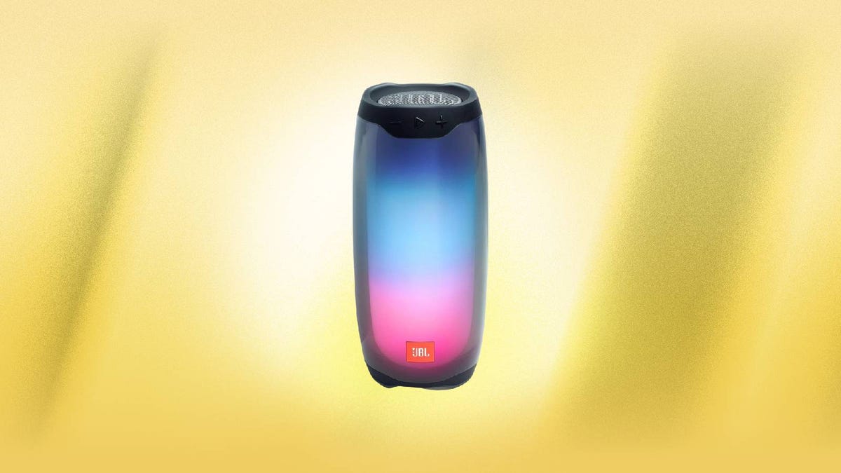 A JBL Pulse 4 bluetooth speaker with multicolored LEDs against a yellow background.