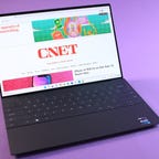 Dell XPS 13 Plus at an angle on a purple background