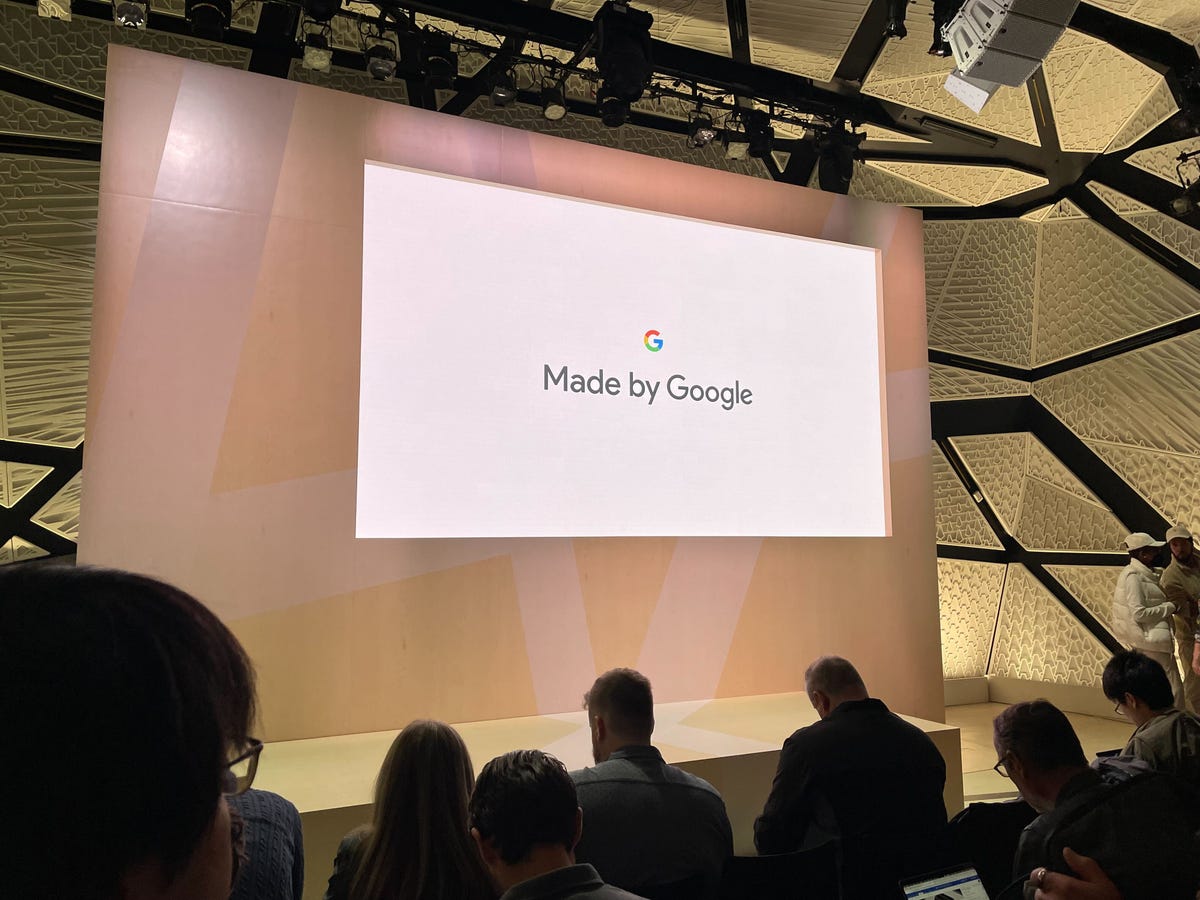 the Google logo and Made by Google are projected on a stage in front of an audience
