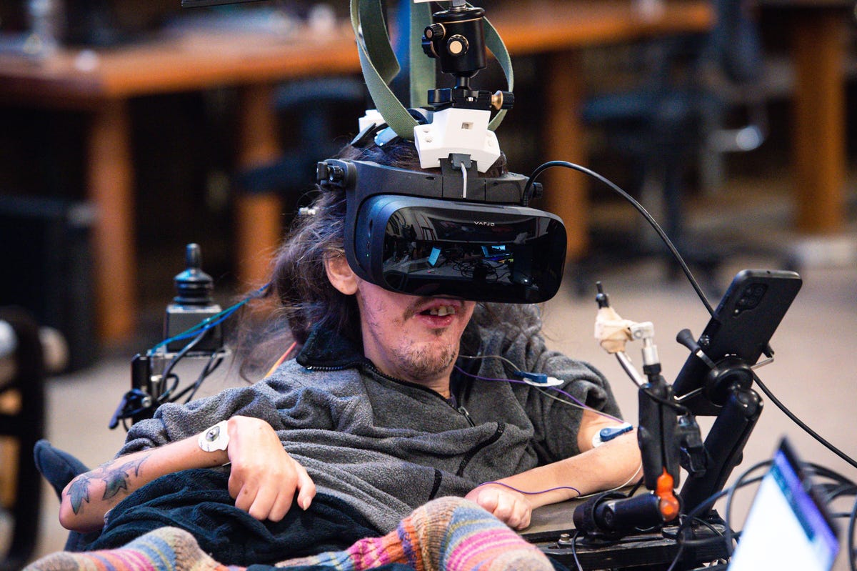 A person sitting in a wheelchair operating a sensor-equipped VR headset