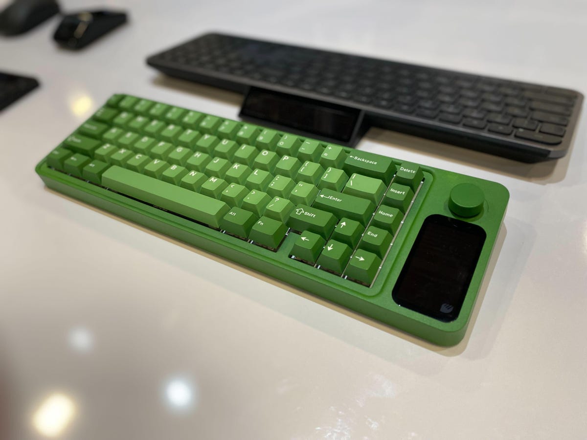A green mechanical keyboard with a black solar cell on the side of it.