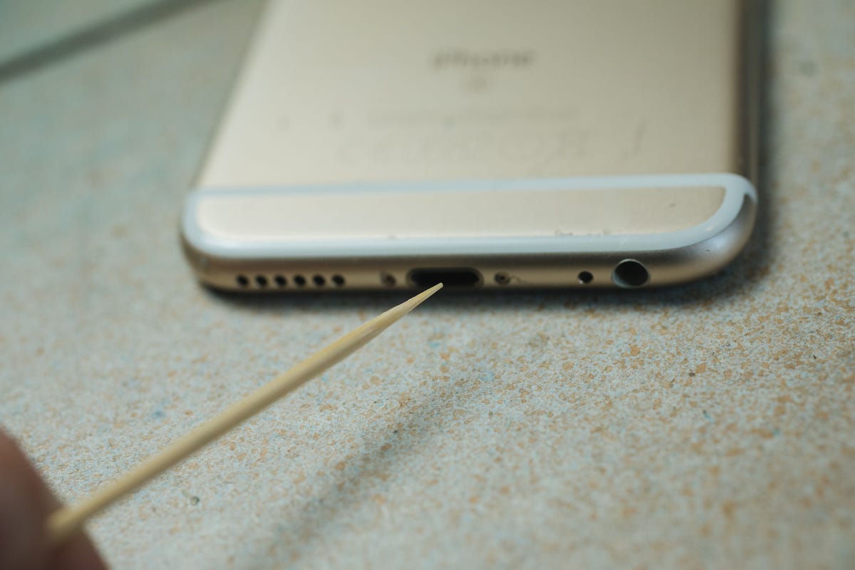 Einen Cocktailstick in den Ladeanschluss eines iPhones stecken