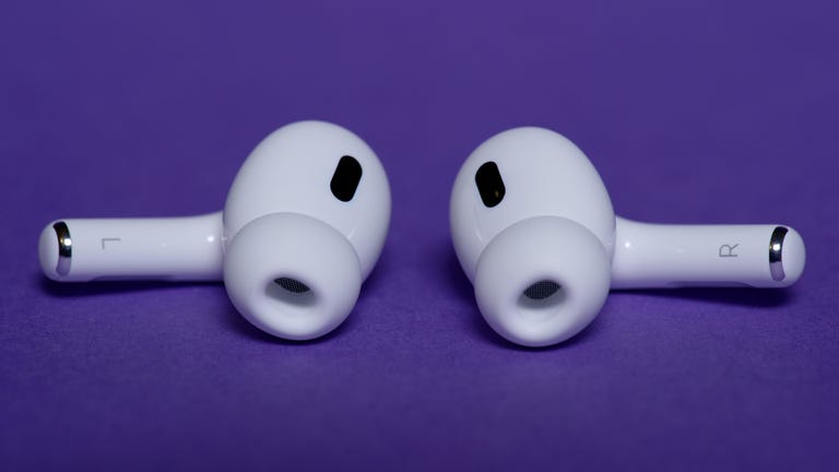 AirPods Pro 2 earbuds lying on a purple surface