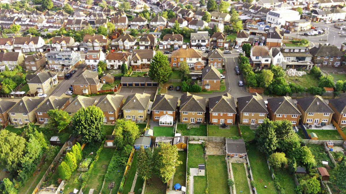 An aerial view of a neighborhood of red brick houses in a row.