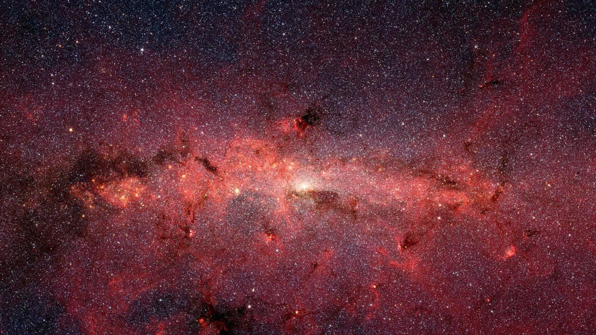 A reddish view of our Milky Way's center, speckled by a huge amount of stars.