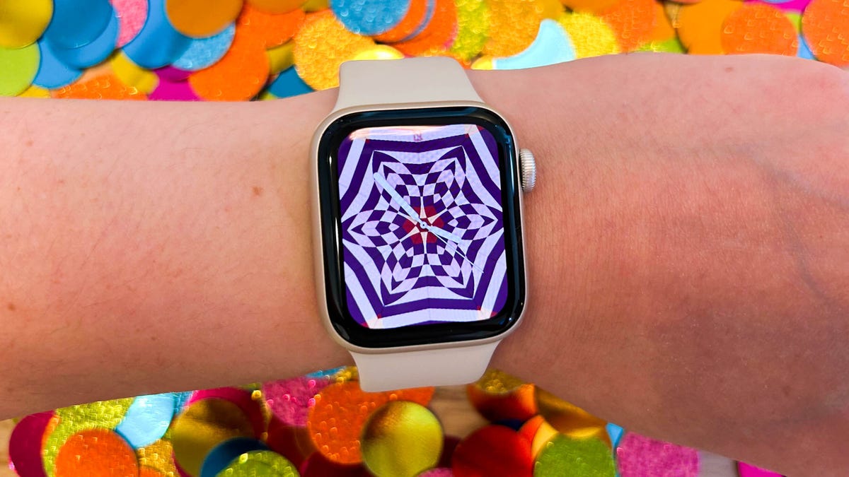 The 2022 Apple Watch SE on someone's wrist against a confetti background