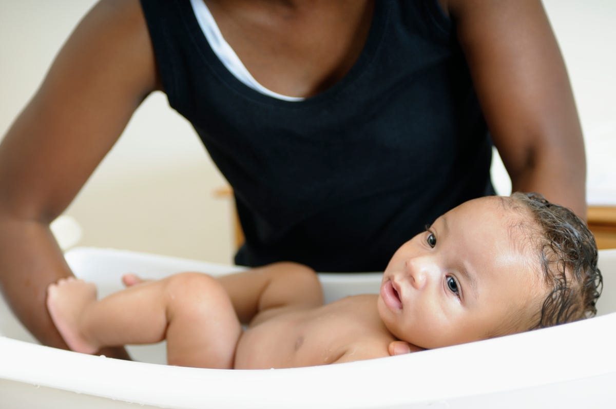 a mother with a newborn in a portable bath