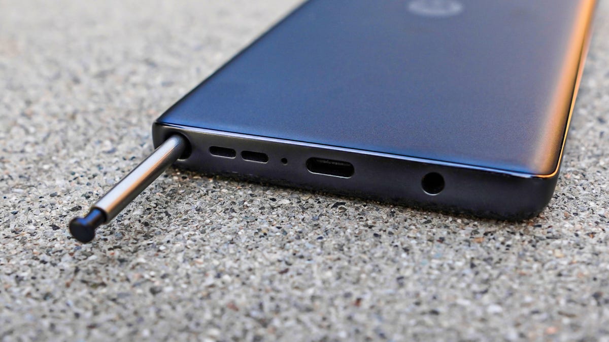 A phone lies face-down while the included stylus protrudes out of its bottom slot.