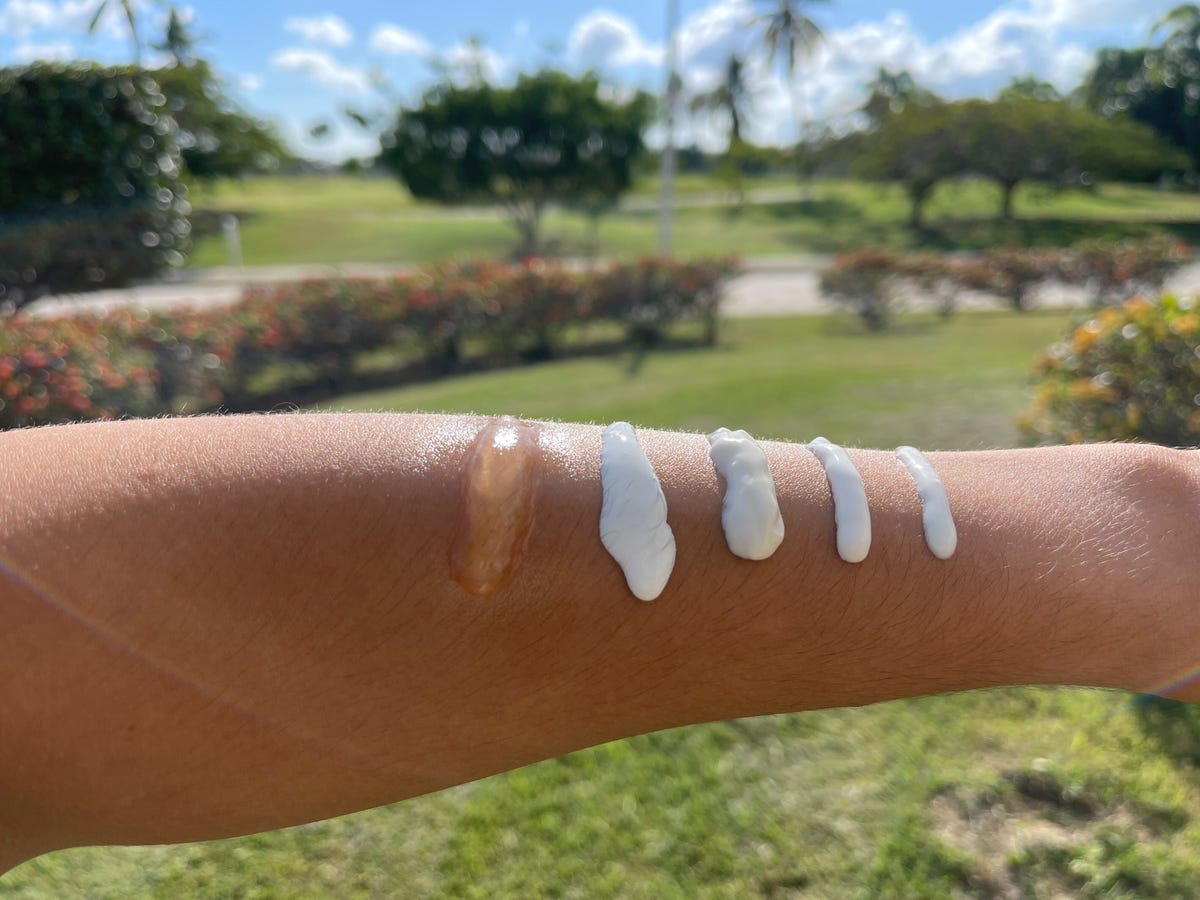 Sunscreen swatches on an arm while outside on a sunny day.