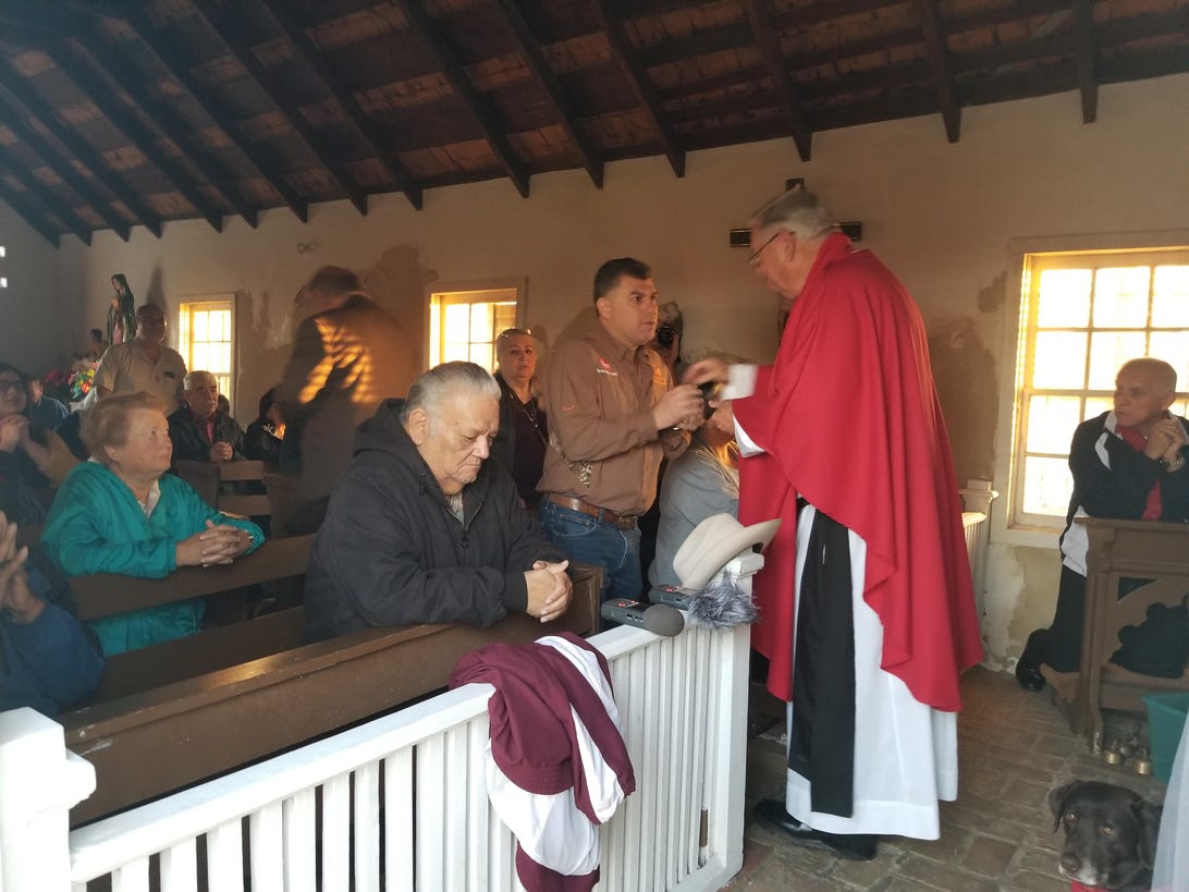 Father Roy Snipes, the parish priest at La Lomita chapel, holds a dawn mass in Mission, Texas. 