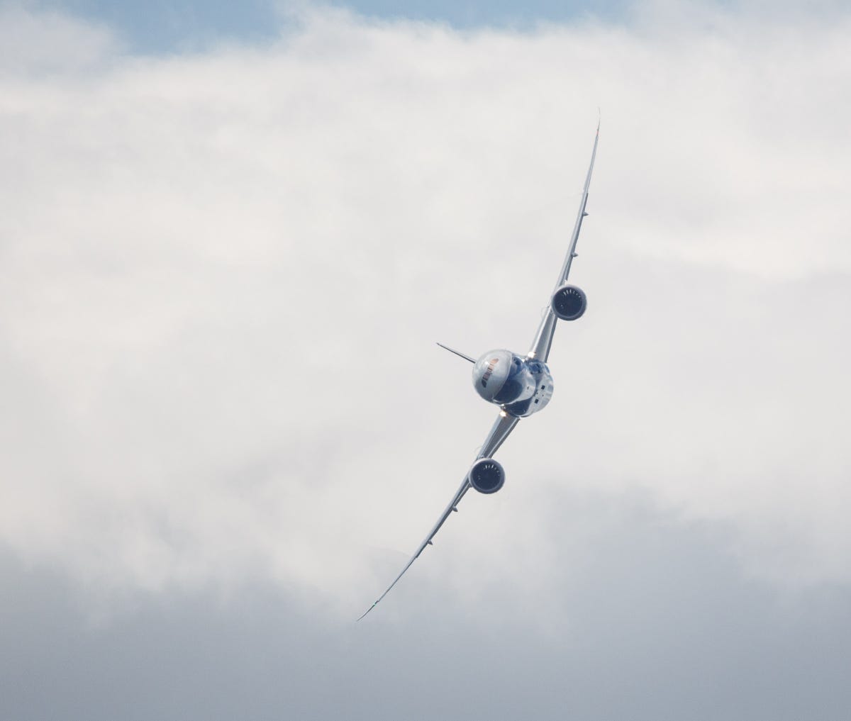 A head-on view of the Boeing 787-9 banking steeply.