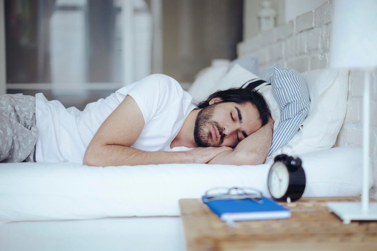 Man sleeping on his left side in bed