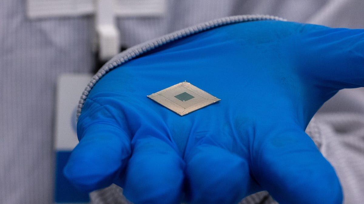 An Intel engineer holds a Meteor Lake processor at an Arizona fab where Intel develops packaging technology for the products
