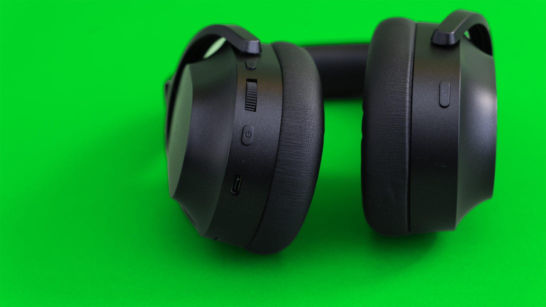 Razer Barracuda Pro gaming headset lying down to show the controls. They are volume dial and power button on the left earcup and the switcher button on the right earcup