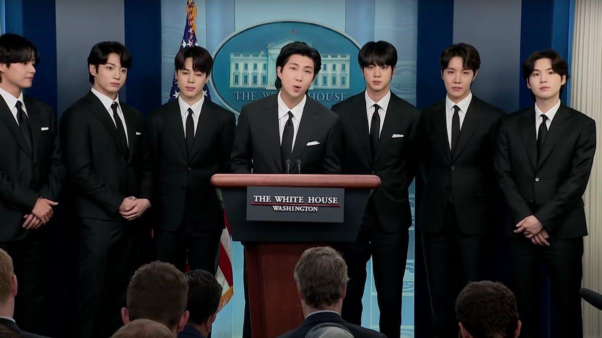 Members of the pop group BTS in dark suits in the White House briefing room