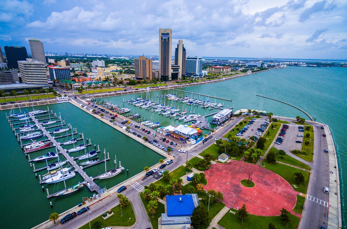 Aerial shot of a Corpus Christi,Texas, marina with sailboats and yachts docked. The Corpus Christi cityscape is in the background and the Harbor Bridge in the distance.