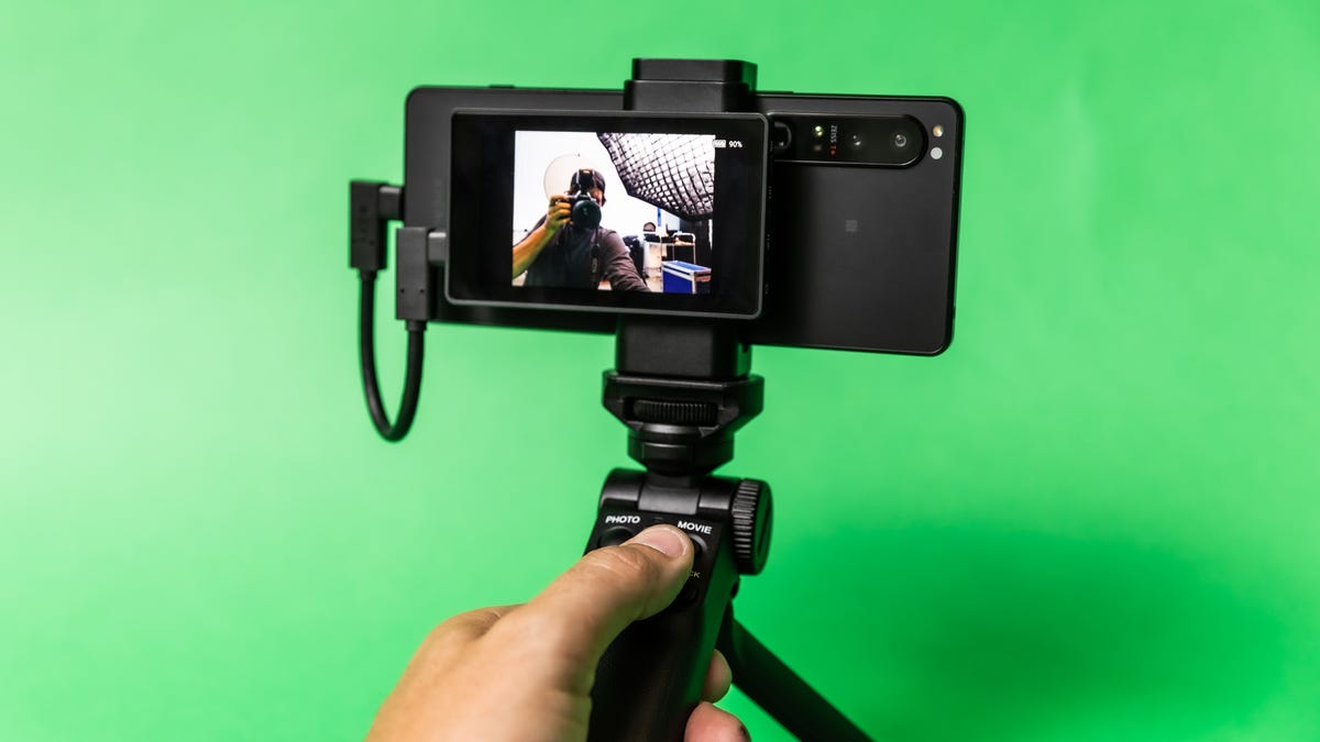 A Sony Xperia 1 IV mounted on a table top tripod with a tiny monitor on the back
