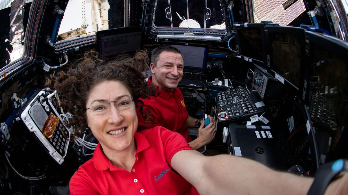 Astronauts Christina Koch and Andrew Morgan inside the International Space Station's seven-windowed cupola.