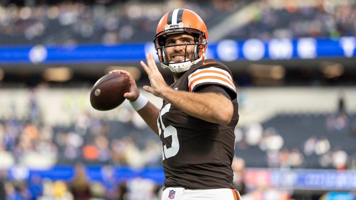 Joe Flacco of the Cleveland Browns, smiling, preparing to throw a ball with his right hand.