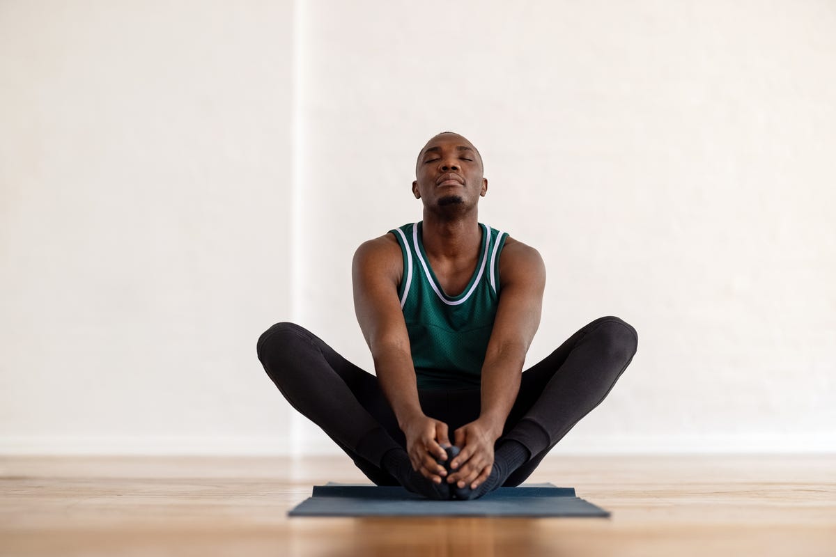 Man meditating ion a yoga mat.