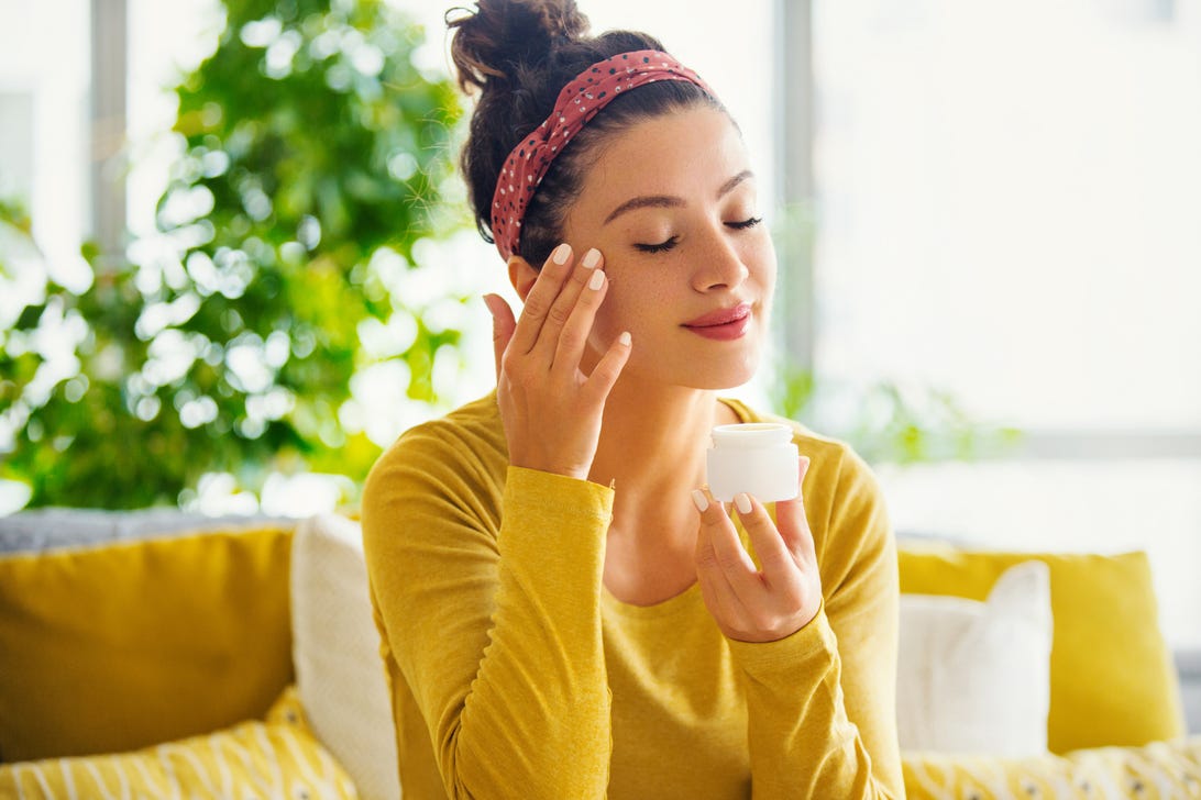 Young woman applying skin products