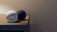 The 5th-gen Amazon Echo Dot and Amazon Echo Dot with Clock sitting on a bedside nightstand.