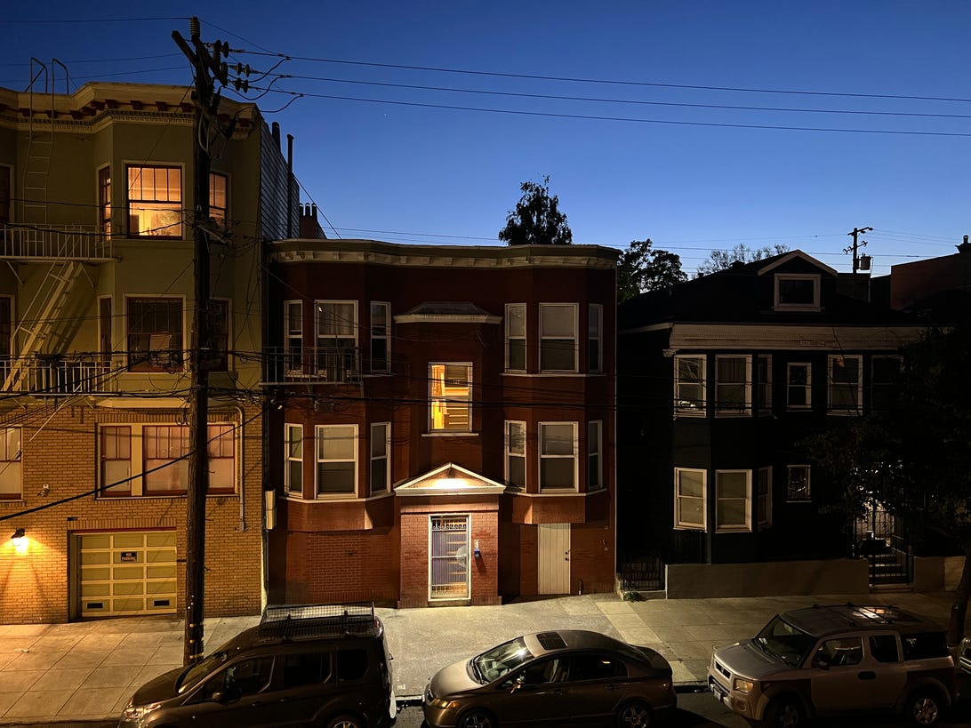 Uma foto no modo noturno do iPhone 13 Pro de uma rua residencial da cidade à noite