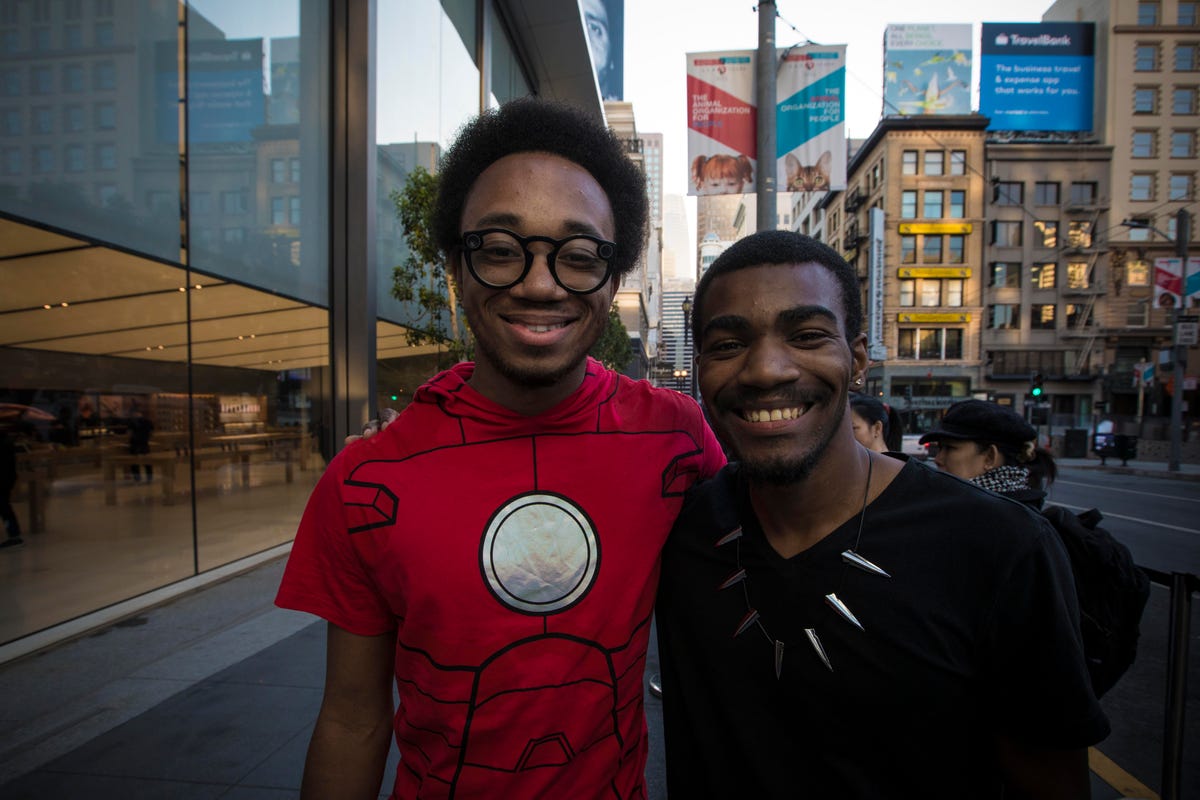 Two men stand in front of the Apple store in San Francisco dressed as Marvel Comics characters.
