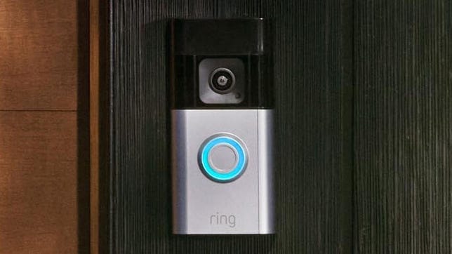 The Ring Battery Doorbell Pro on a wooden door frame.