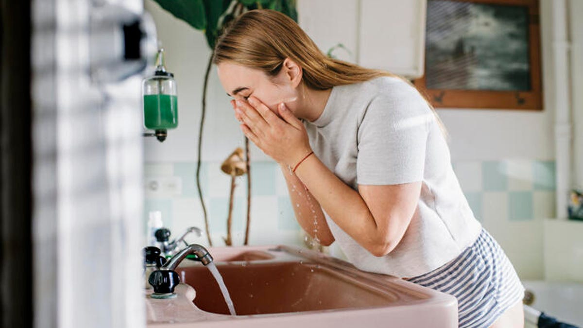 young woman washing her face
