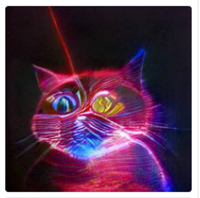A cat made of mostly pink laser light.