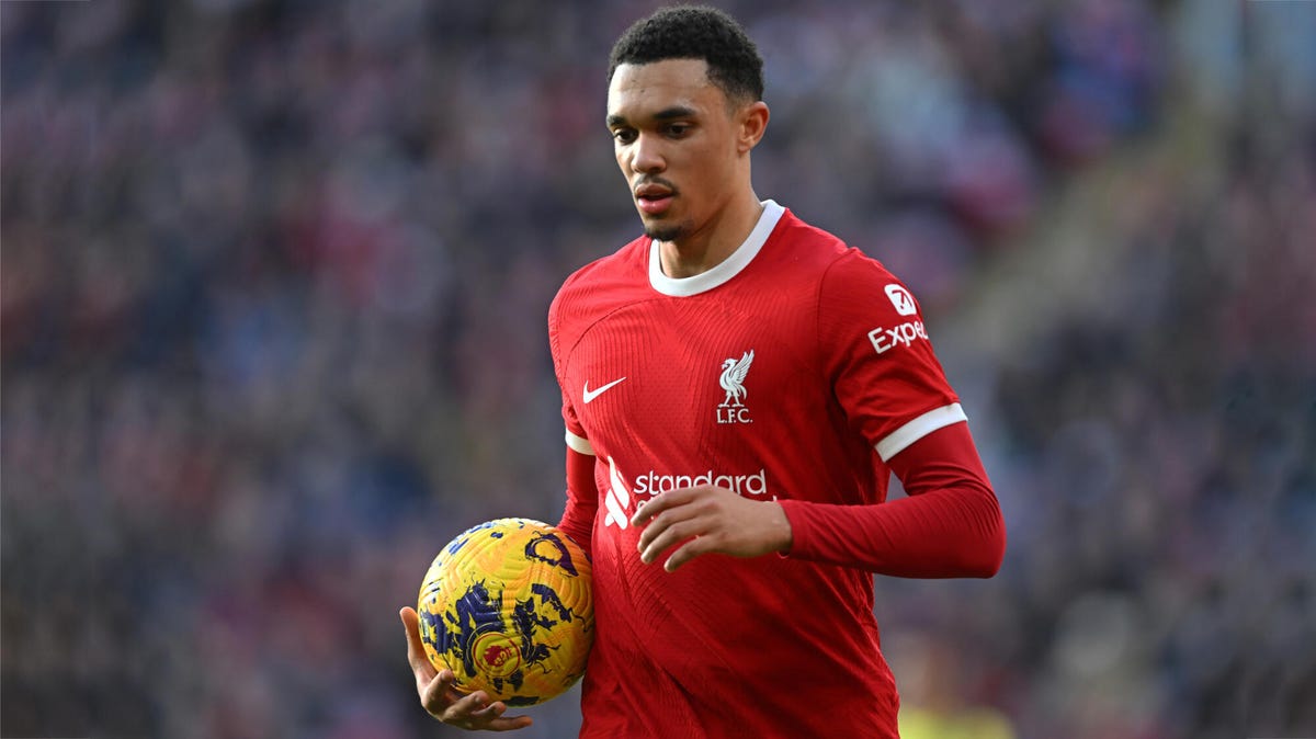Trent Alexander-Arnold of Liverpool looking downwards, holding a yellow ball in his right arm.