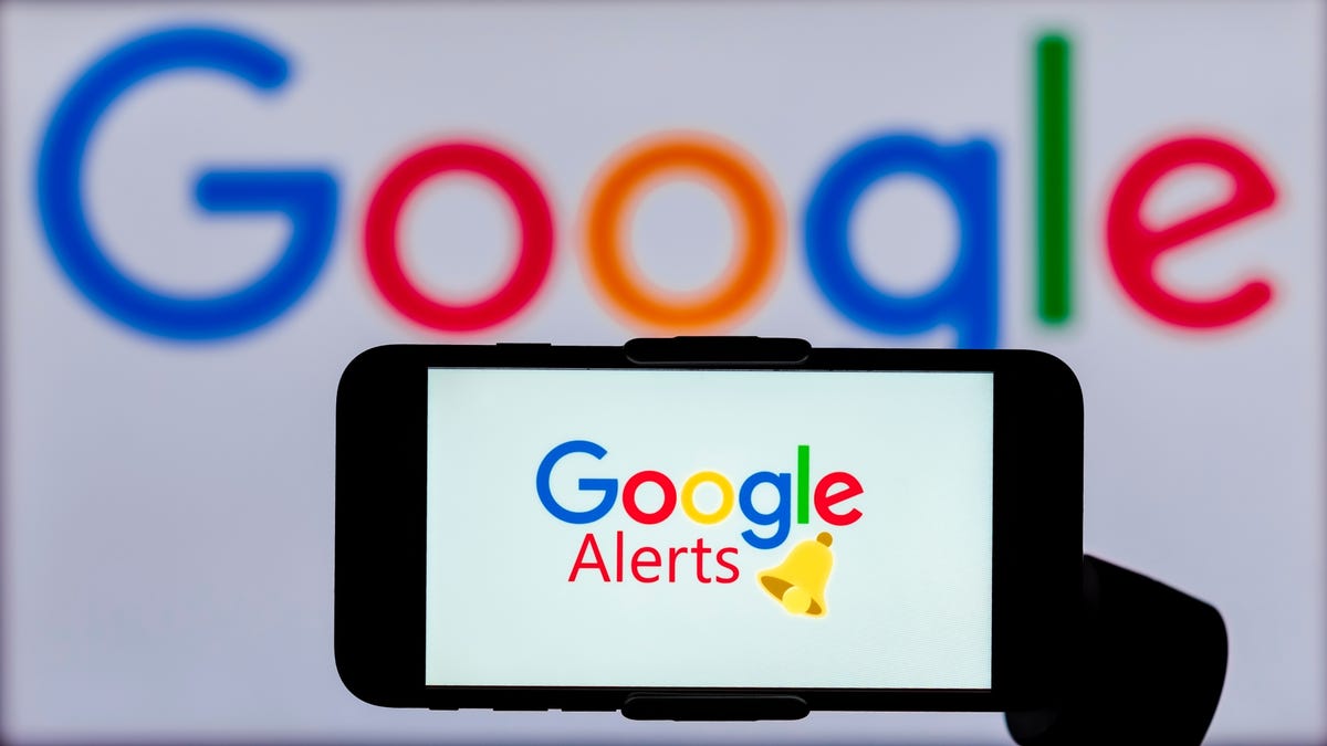 Logo Google Alerts affiché sur l'écran d'un téléphone mobile avec un logo Google en arrière-plan