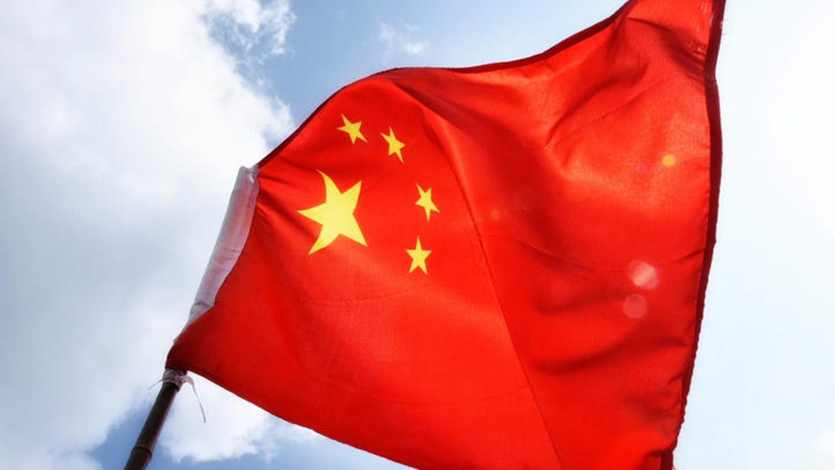Low Angle View Of Chinese Flag Waving Against Sky