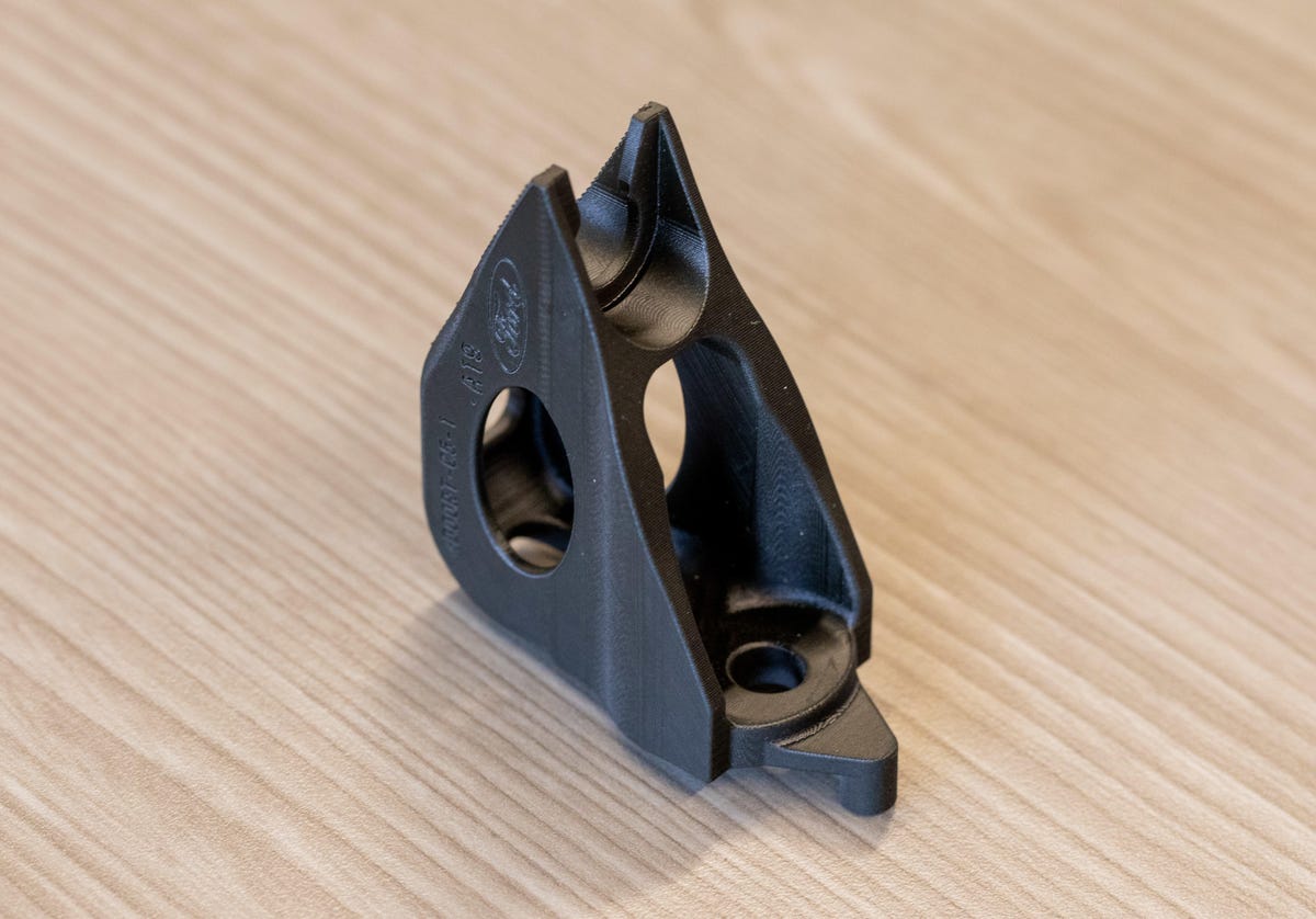 This Carbon 3D-built bracket, while unspectacular, is used inside Ford Mustangs. 3D printing enables lighter parts than are possible with metal manufacturing.