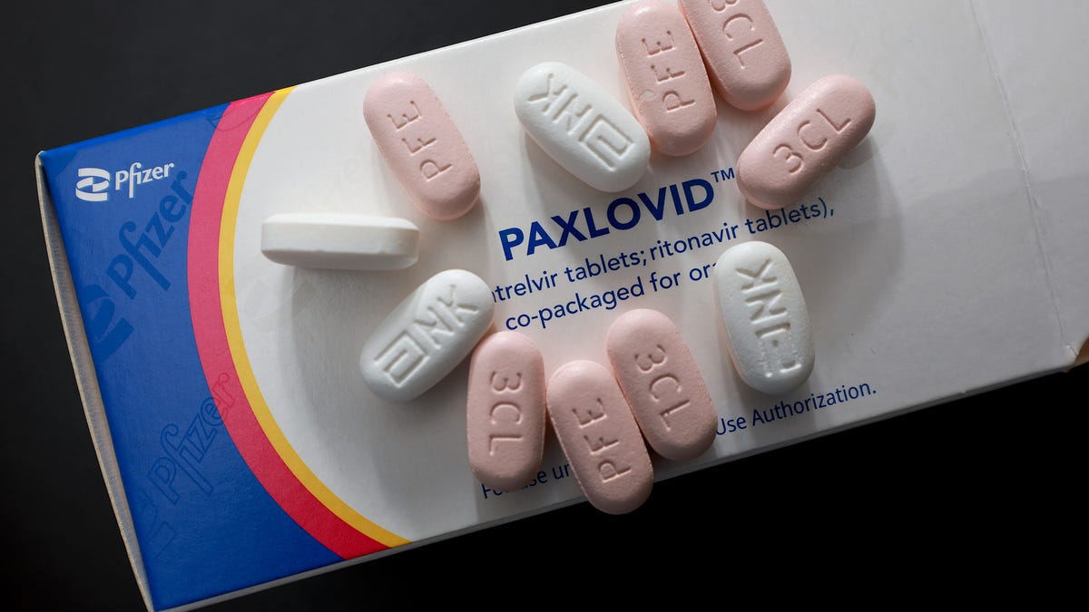 Some Paxlovid pills laid out on a cardboard box