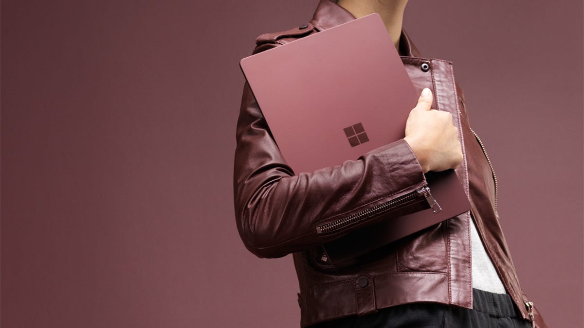 A model holds a Microsoft Surface laptop