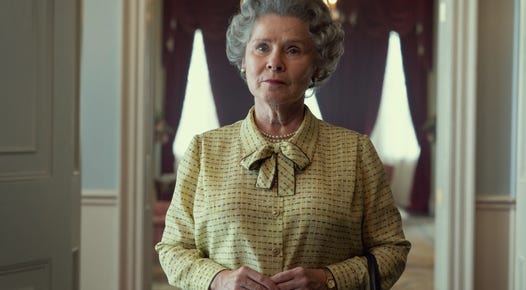 Imelda Staunton as The Queen standing indoors looking at something off screen